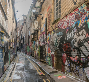 Schmale Gasse in Bristol, deren W&auml;nde vollst&auml;ndig mit bunten Graffiti und Street-Art bedeckt sind.