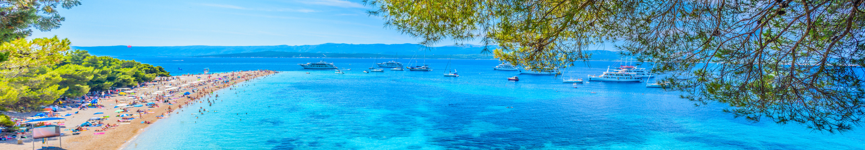 Bekannter Strand Zlatni Rat auf der Insel Brač in Kroatien mit t&uuml;rkisblauem Wasser, Yachten und Badeg&auml;sten