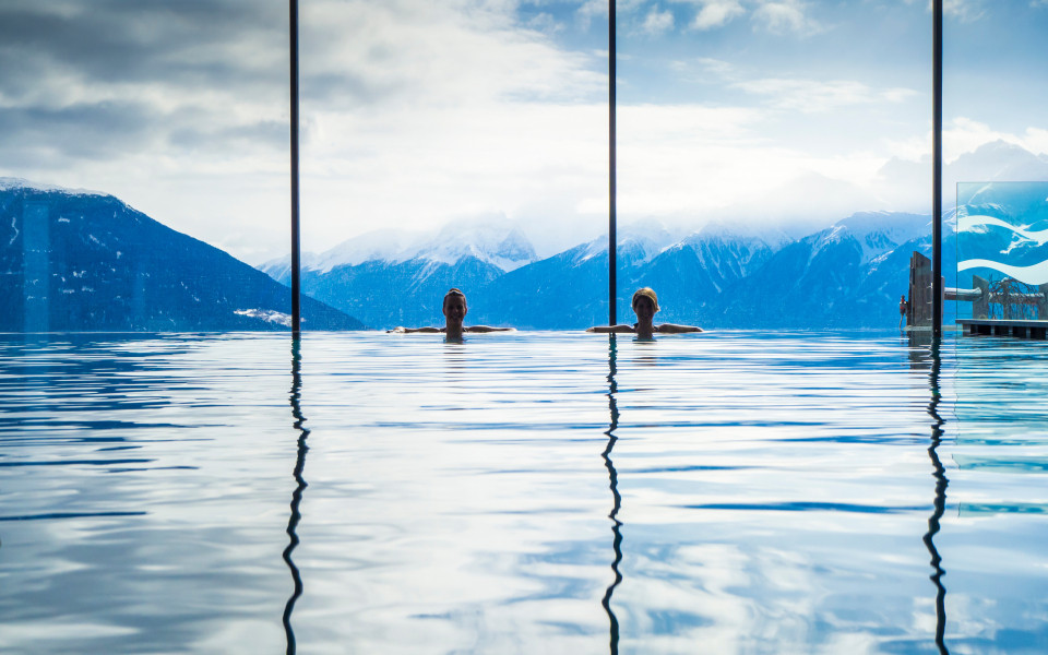 Frauen genießen den Panoramablick vom Pool in die Alpen